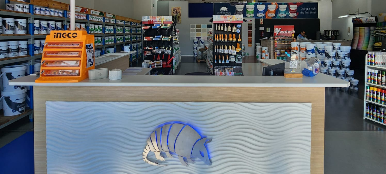 Paint shop Tableview WeatherPrufe customer browsing colour charts and paint finishes inside the store.