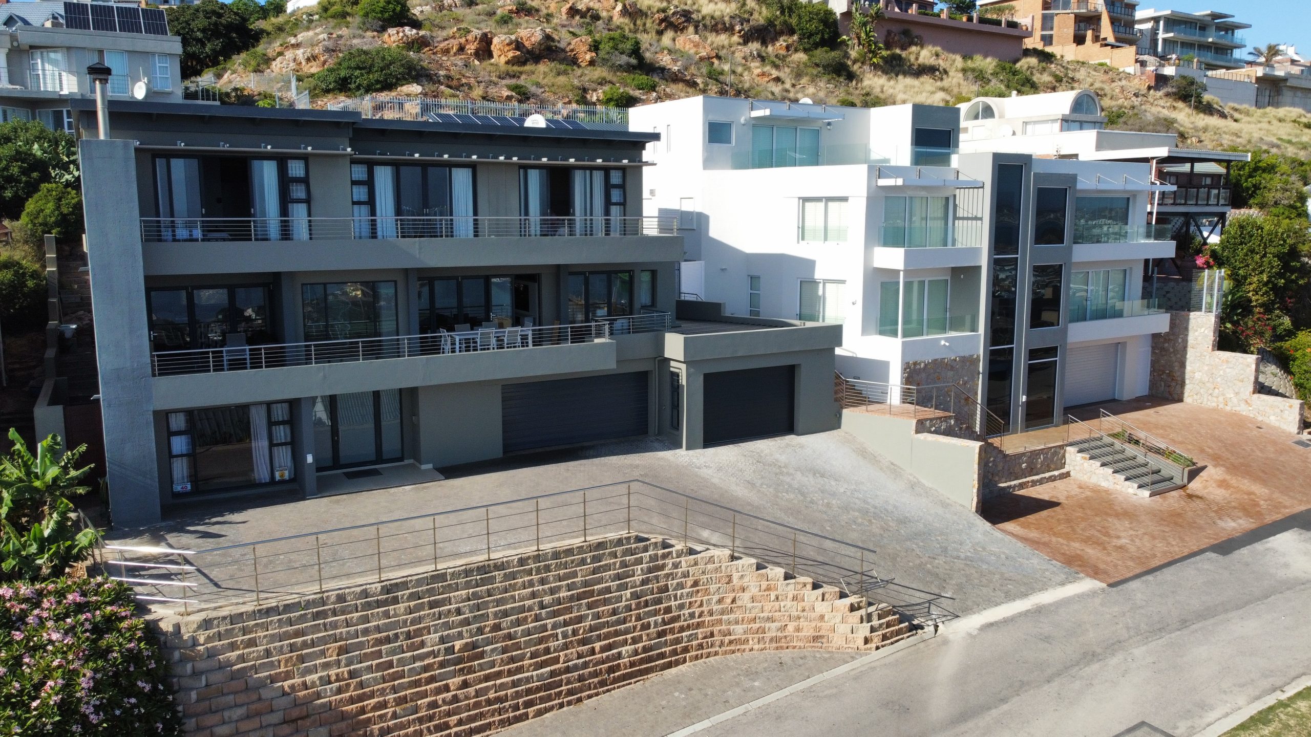 A painter carefully repainting weather-worn walls in Muizenberg, protecting the surface from constant salt-laden sea spray.