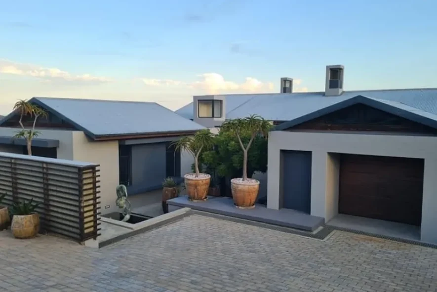 Professional roofer applying membrane waterproofing to a flat roof in the Western Cape to prevent leaks.
