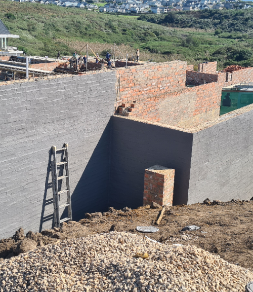 Paint rollers and brushes used to apply Elastocryl coating onto concrete wall.
