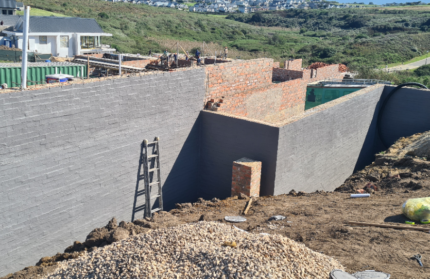 Paint rollers and brushes used to apply Elastocryl coating onto concrete wall.