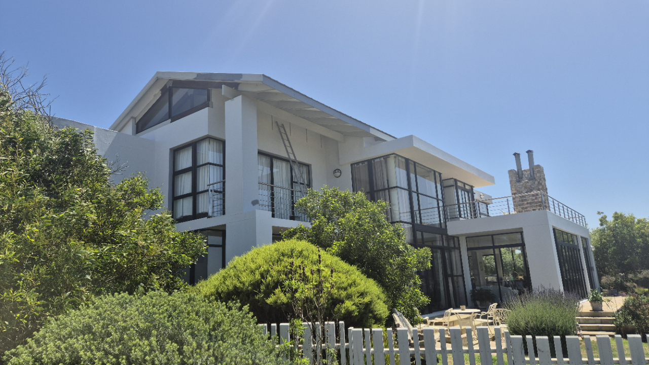 WeatherPrufe team pressure washing exterior walls at Oubaai Estate to remove salt residue and prepare surfaces for restoration and repainting.