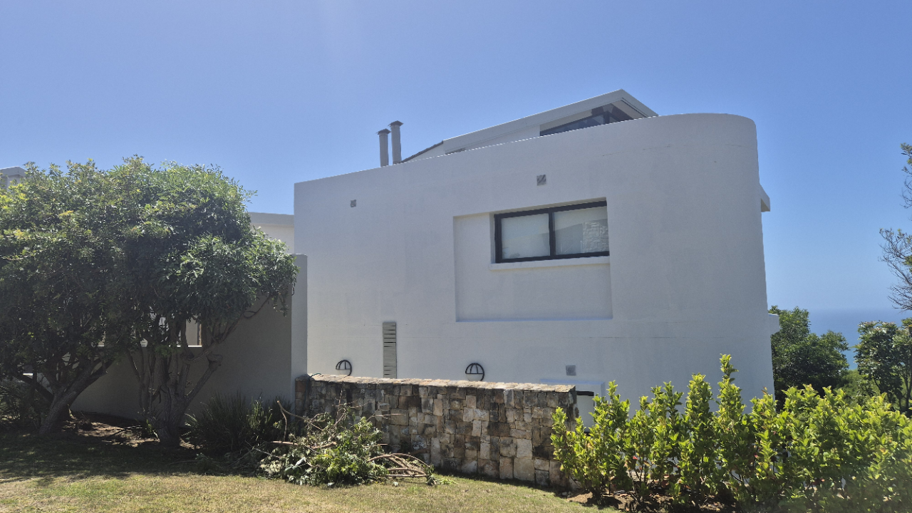 Contractor rolling Weatherseal acrylic coating onto coastal home façade in Oubaai to provide UV stable and long-lasting protection.