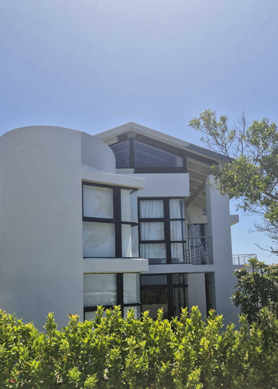 Professional painting crew applying WeatherPrufe coatings to a modern Oubaai property with scaffolding and safety equipment.