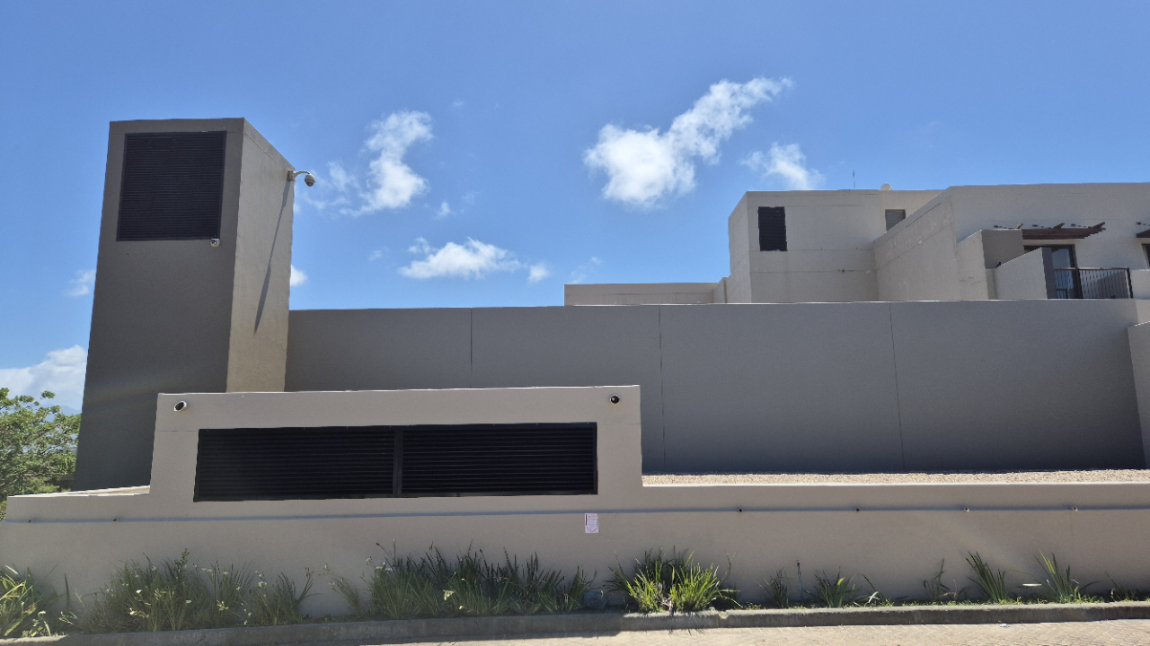 Exterior walls being coated with WeatherPrufe Weatherseal for durable, UV-resistant finish.